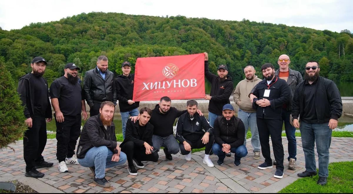 Команда «Хицунов» с флагом бренда на выездном мероприятии